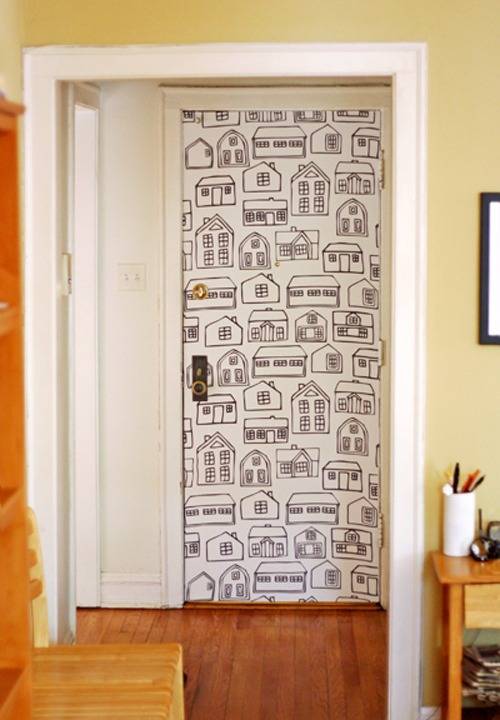 A door in a house with drawings of houses covering it.