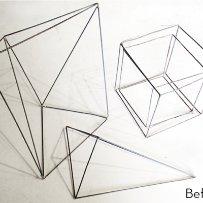 Cubes and pyramids shaped from metal wire.