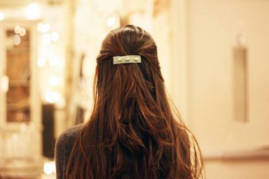 The back of a brunette woman's hair showing her scrunchie.