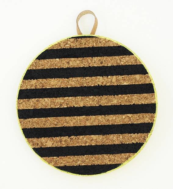 A corkboard has black horizontal stripes and a hanging loop.