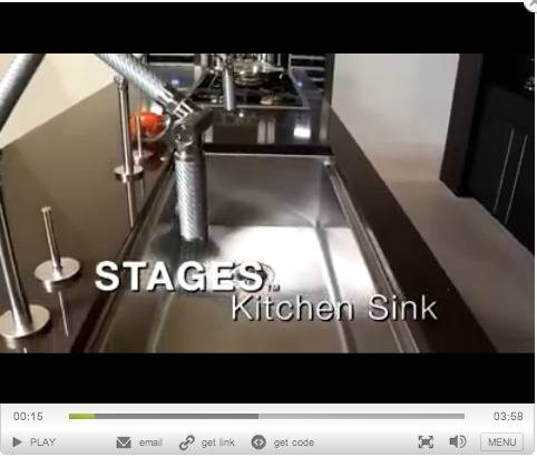 A recessed kitchen sink is in a black kitchen counter.