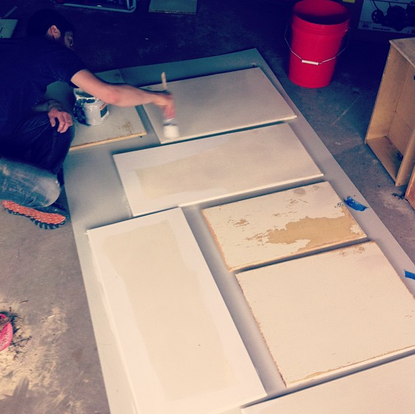 A bunch of stripped cabinet panels being repainted.