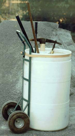 Garden tools sitting in a round white container that is strapped to a lift.