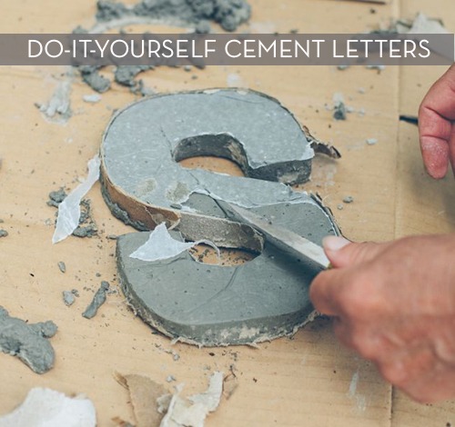 A letter S being carved out of cement.