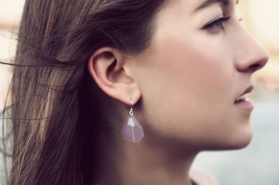 Woman facing sideways with a translucent earring.