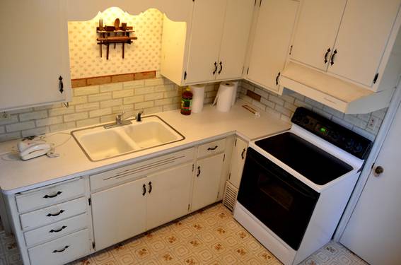 A white kitchen with a black-and-white stove.