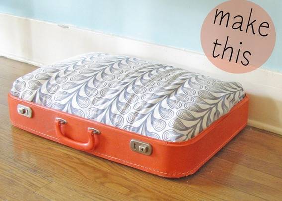 An orange suitcase with white and grey designs on top.