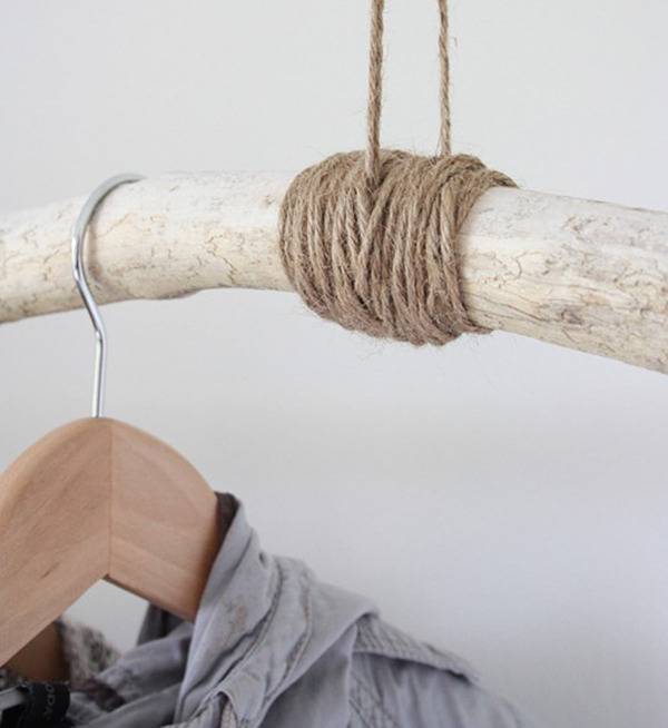 An article of clothing hanging on a rod dangling with twine.