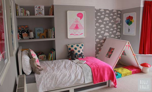 A bed is in a room decorated with a lot of pink.