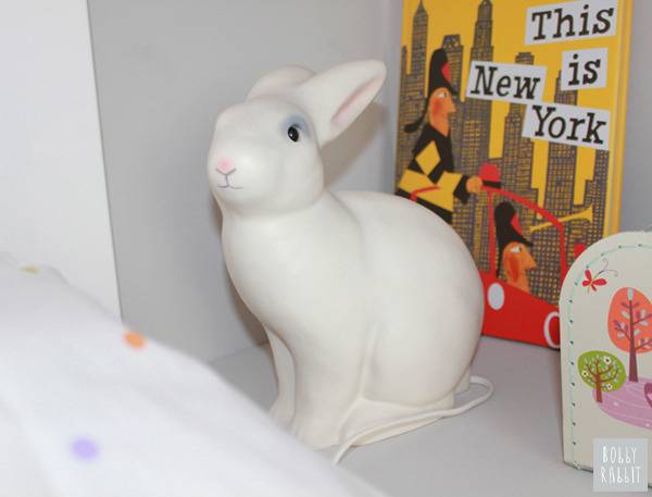 A white rabbit night light sits on a shelf.