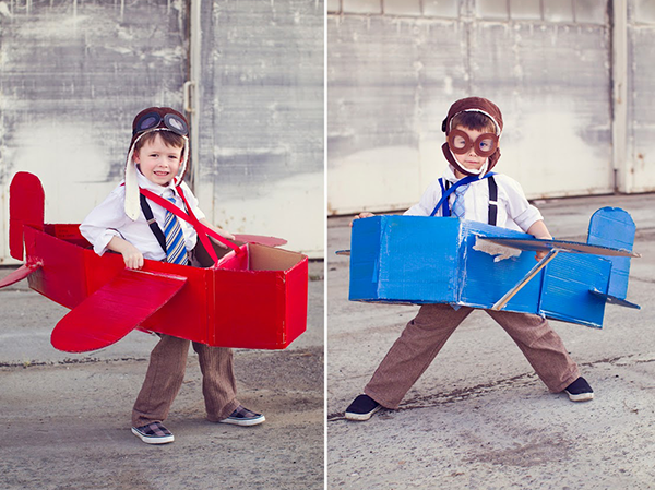 Two boys with boxes that look like paper planes.