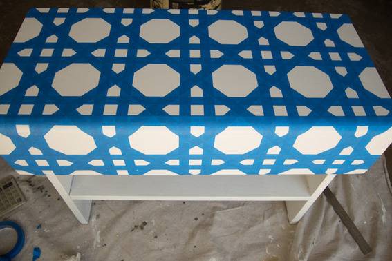 A blue and white table cloth on a white bench.