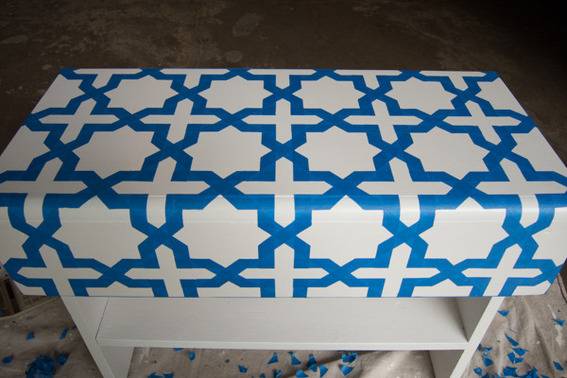 A table with a white and blue designed tablecloth.