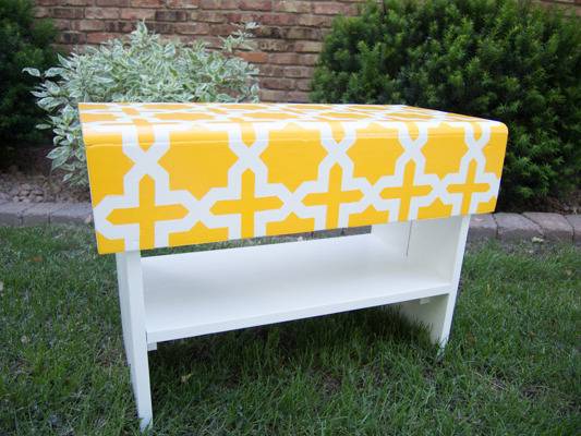 A white shelf has a yellow top with a white cross design.