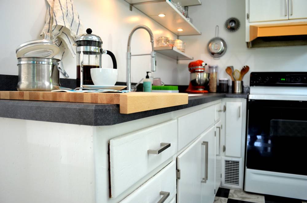A well-lit white kitchen with appliances.
