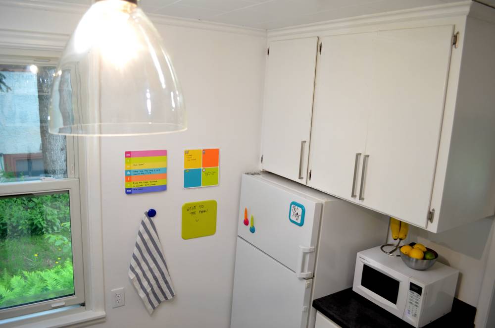 Clear dome light next to a wall with colored papers in a kitchen.