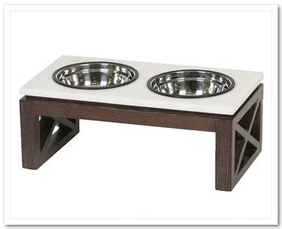 A raised pet feeding bowl contains a food bowl and a water bowl and is made of wood with a white top.