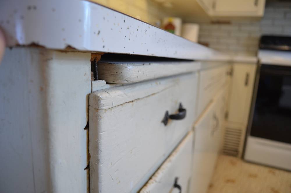 There are drawers on a white cabinet in a kitchen.