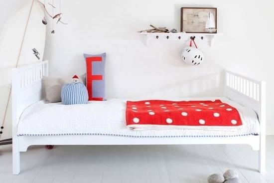 A modern childrens bed with red accents.
