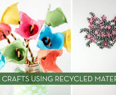 Cardboard or paper flowers are in a jar and hanging on a wall.