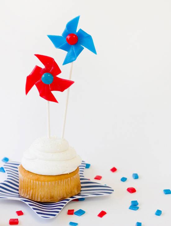 A cupcake with blue and red pinwheels on it.