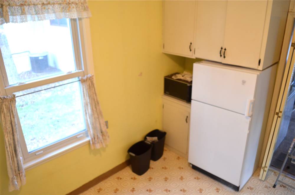 Kitchen appliances sit in a kitchen with a window and yellow walls.