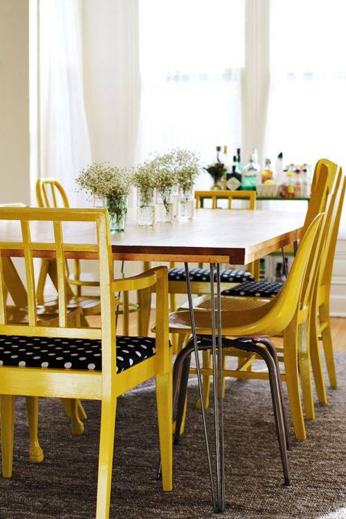 Yellow and black chairs around a table near a window.
