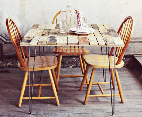 Wooden dining table with iron legs with wooden chairs.
