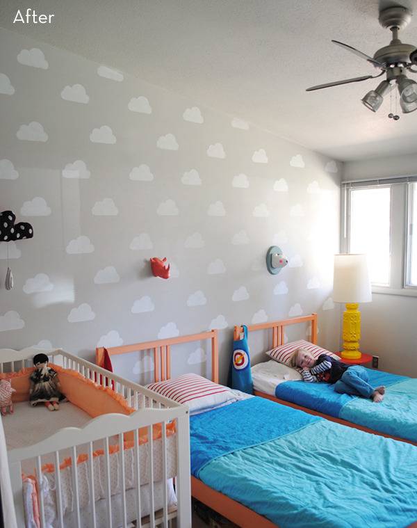 A kids room with white walls painted with clouds
