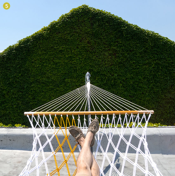 Two legs are laying on a white hammock.