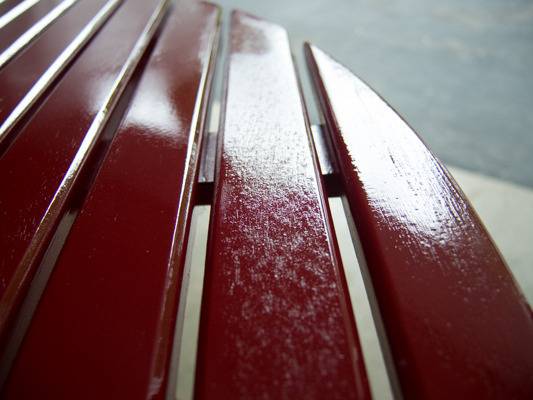 Red slats of wood have a sheen on them.