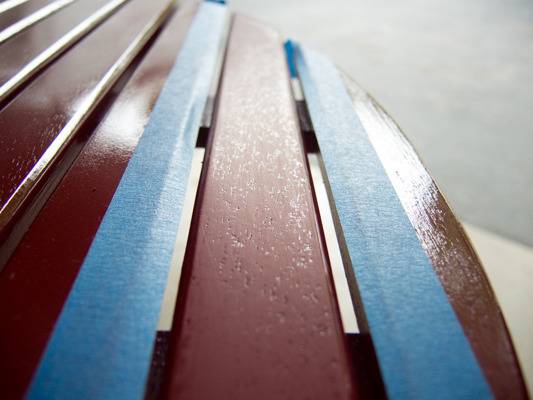 Painted maroon bench seat with blue masking tape.