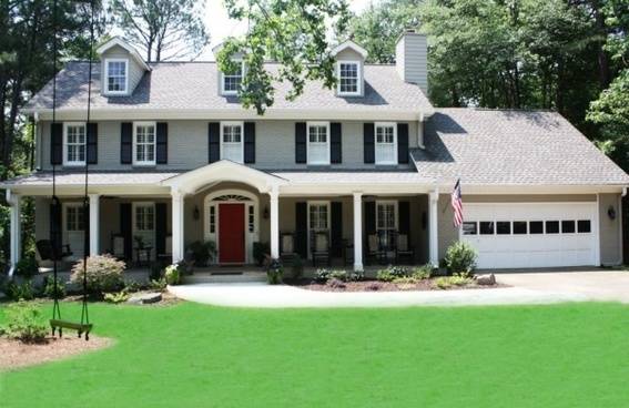 A large two story house with a garage and big green lawn