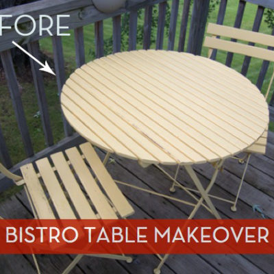 Round light wood bistro table with two chairs around it sitting on a wooden deck.