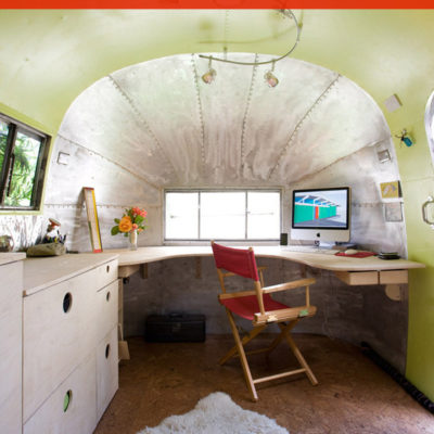 A red chair is sitting at a computer in an RV.