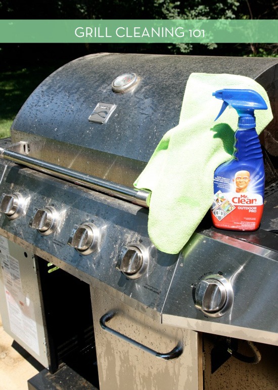 Bottle of spray cleaner with a rag on top of a stainless steel grill.