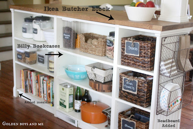 Kitchen island converted to a bookcase with basket, shelves, and bowls inside.