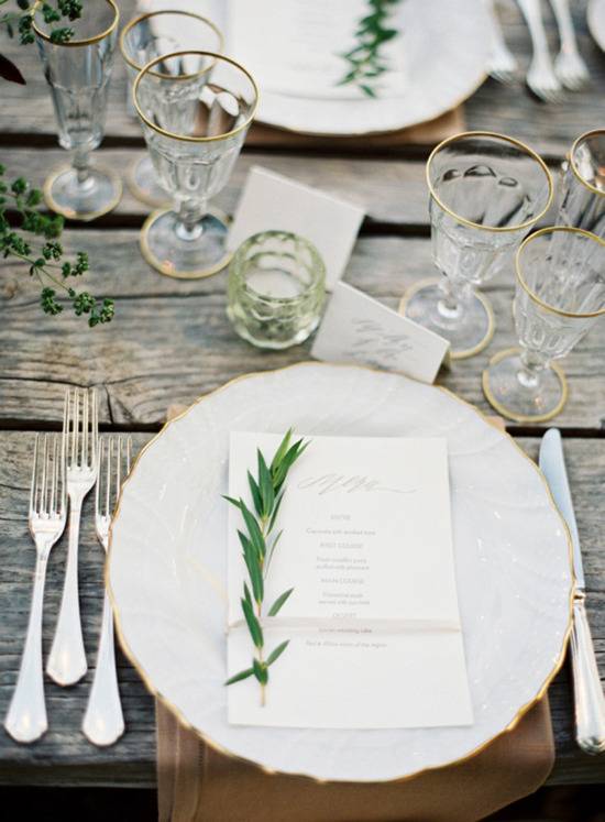 Formal dinnerware settings on an old wooden tabletop.