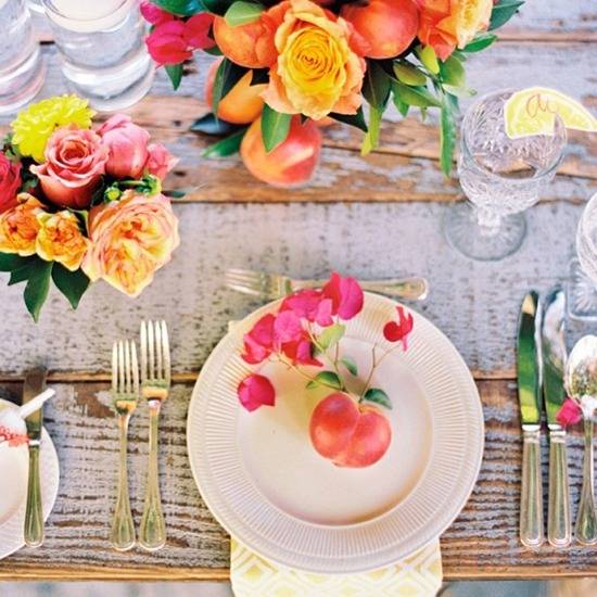 Flowers are set with dishes on a wooden table.