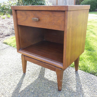 A wooden nightstand sits outside.