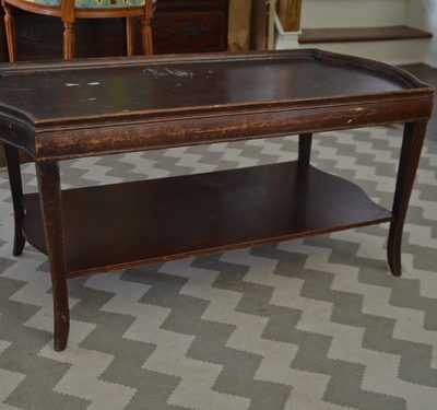 A wooden table with Knicks and scratches on it.