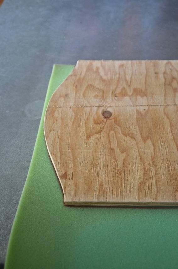 A wooden board sitting on a green cloth.