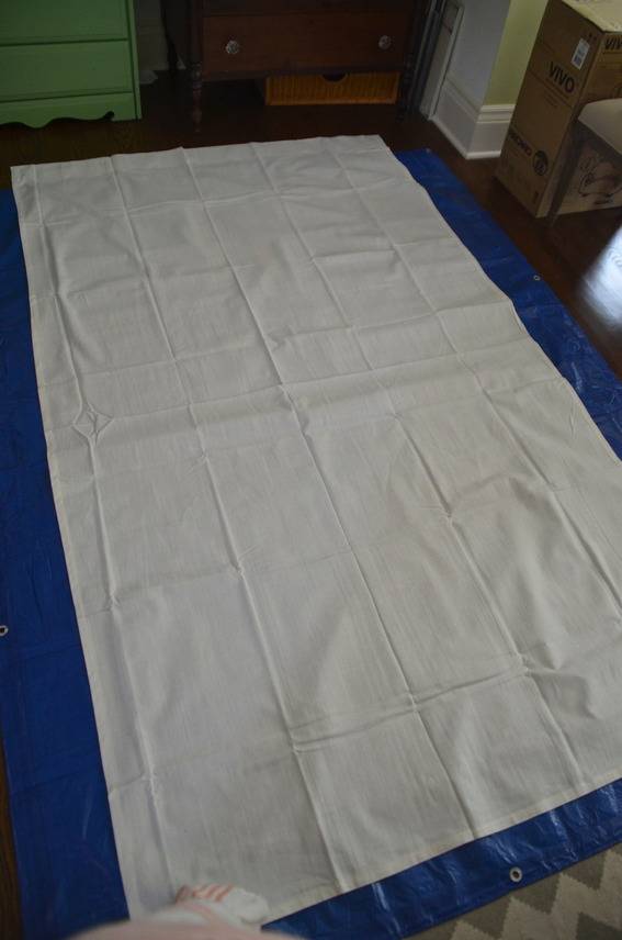 A piece of white cloth is laid out on a blue plastic tarp.