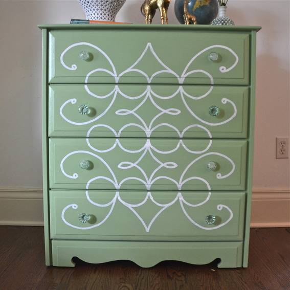 Light green dresser painted with a frilly pattern on the front.