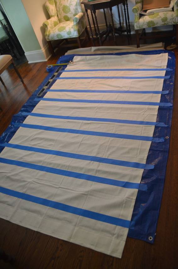 Blue tape is crossing a white material on a blue tarp.