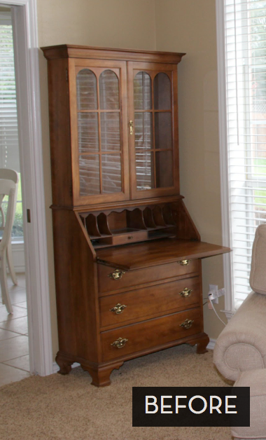 A wooden armoire is open to reveal a built in desk