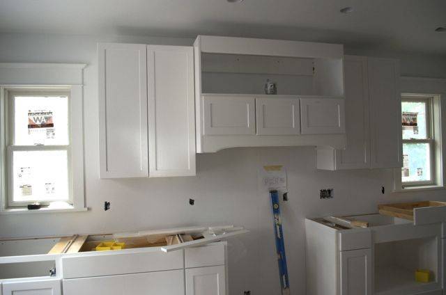 A kitchen has white cabinets and counters.