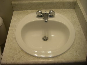 A white sink with a metal faucet.