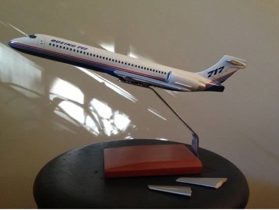 A model airplane is sitting on a small black table.