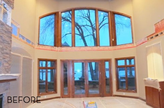 Large arched window entryway overlooking a tree with no leaves.